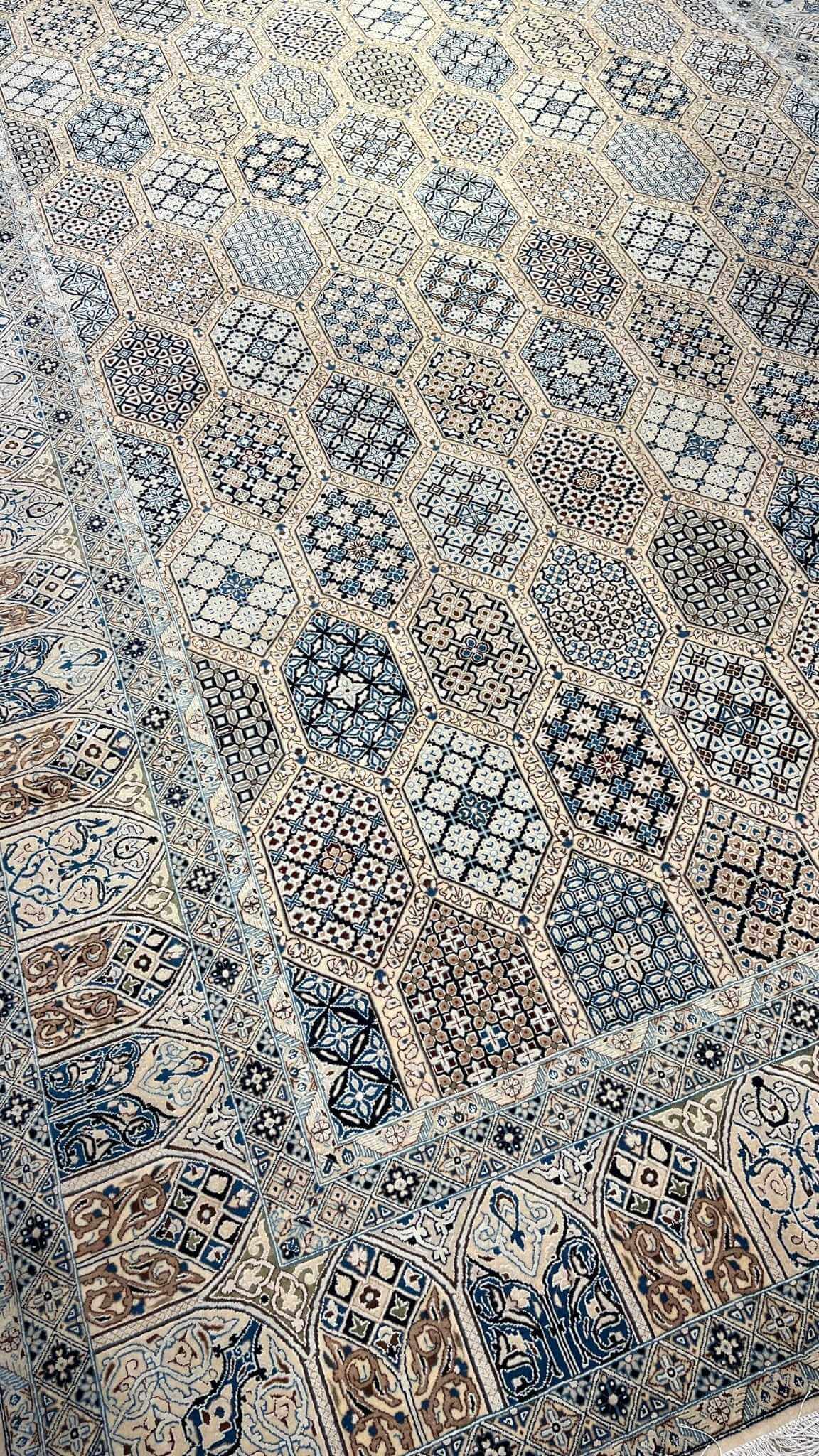 Persian Nain rug in beige, blue, and ivory with intricate hexagonal patterns.